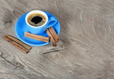 mavi bir fincan ve tarçın ahşap bir masa üzerinde kahve. kopya alanlarda