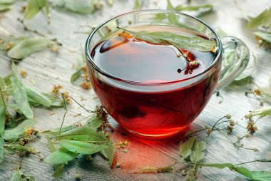 bitkisel çay. ahşap bir masa ıhlamur çayı fincan. soğuk algınlığı ve grip için geleneksel ilaç.