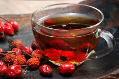 Köpek gül gül berries.dog çay. ahşap bir masa üzerinde iyileştirici kuşburnu çayı fincan. vitamini çay.