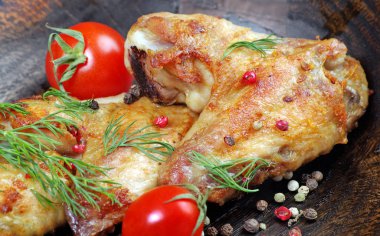 Fırında tavuk kanat ahşap arka plan üzerinde. Tavuk kanatları, domates ve biber karışımı, yakın çekim