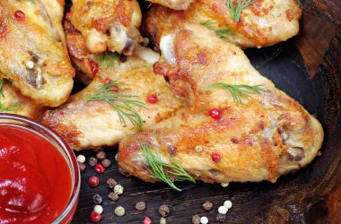 Fırında tavuk kanat ahşap arka plan üzerinde. Tavuk kanatları, ketçap ve biber karışımı, yakın çekim