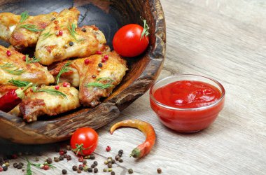 Fırında tavuk kanat ahşap arka plan üzerinde. Tavuk kanatları, ketçap ve biber karışımı, yakın çekim
