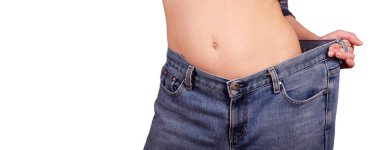İnce kız beyaz izole büyük kot pantolon. Genç bir kadın bir slimmed resimde görülmektedir. Kilo kaybı kavramı 