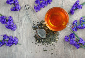 egy csésze tea és tavaszi virágok egy fa asztalon