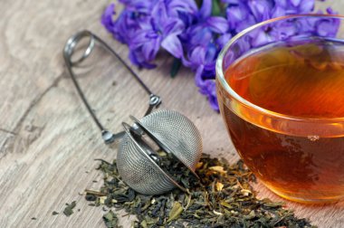 Tahta bir masada bir fincan çay ve bahar çiçekleri