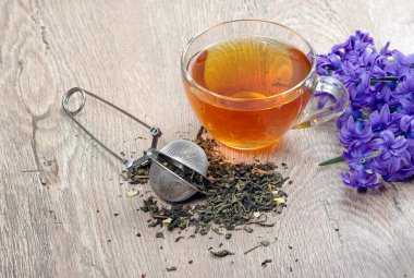 Tahta bir masada bir fincan çay ve bahar çiçekleri