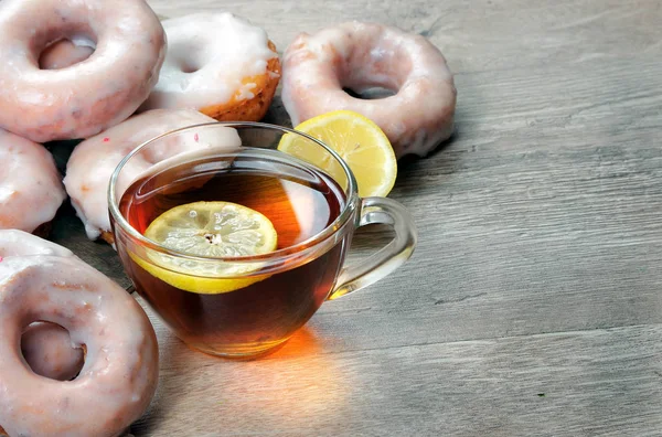 Donuts Een Kopje Thee Een Houten Tafel — Stockfoto