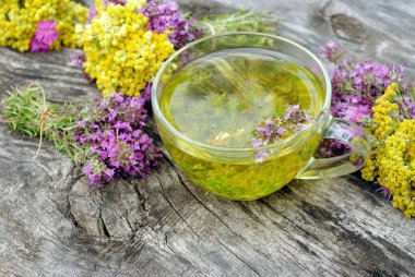 Ahşap bir masada bitki çayı ve şifalı otlar fincan. taze kekik ve immortelle. soğuk algınlığı ve grip çare