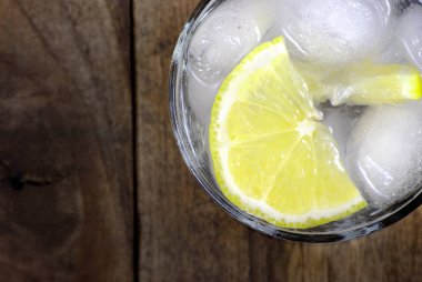  ahşap bir masa üzerinde buz ve limon ile soğuk su cam. yakın kapatın. üst görünüm