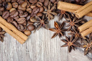 yıldız anason, tarçın ve ahşap bir masada kavrulmuş kahve çekirdekleri. kavrulmuş kahve ve baharatlar. üst görünüm. kopyalama alanları.