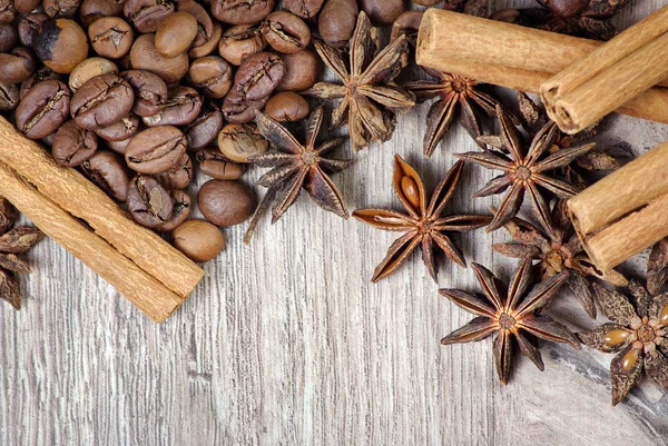 yıldız anason, tarçın ve ahşap bir masada kavrulmuş kahve çekirdekleri. kavrulmuş kahve ve baharatlar. üst görünüm. kopyalama alanları.