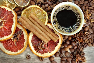 Noel geçmişi. kurutulmuş limon, greyfurt, anason yıldız, tarçın, kahve fincan ı ve kavrulmuş kahve çekirdekleri ahşap bir masada. kahve fincan, baharat ve kurutulmuş meyve. 