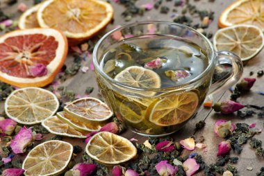 ahşap bir masa üzerinde çay ve kurutulmuş limon fincan. kurutulmuş gül çiçekleri ile yeşil çay.
