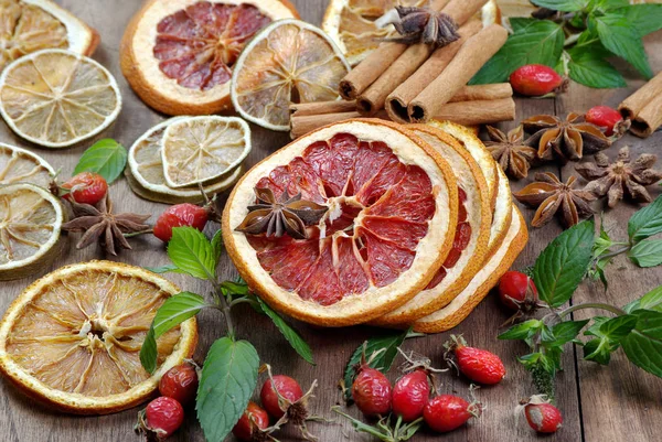 Christmas background. dried lemon, orange, grapefruit, anise stars, mint leaves, cinnamon, and rose hips on a wooden table. spices and dried fruits copy spaces. alternative medicine.