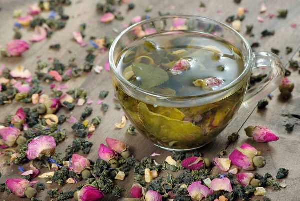 green tea. cup of green tea with flowers and fruit pieces. blend tea