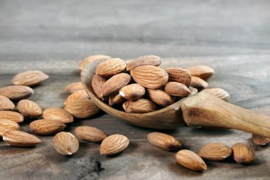 ahşap bir masada bir kepçe badem fıstığı yakın