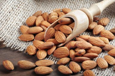 ahşap bir masada bir kepçe badem fıstığı yakın