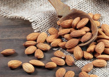 ahşap bir masada bir kepçe badem fıstığı yakın