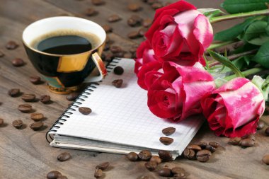 kahve konsepti. güller ve kahve. kahve fincan ve ahşap bir masa üzerinde gül bir buket. sabah kahvesi ve not. kopyalama alanları.