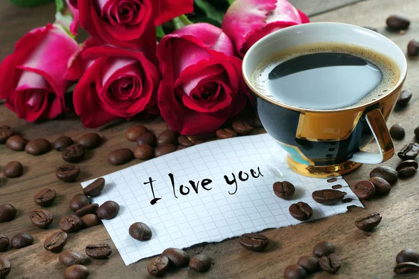 coffee concept. roses and coffee. cup of coffee and a bouquet of roses on a wooden table. morning coffee and note. copy spaces.