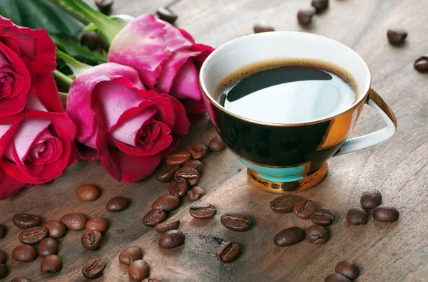 roses and coffee. cup of coffee and a bouquet of roses on a wooden table.