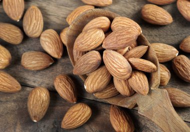 Bademler bir kaşıkta, ahşap bir masada, yakın plan.