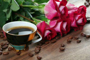 güller ve kahve. kahve fincan ve ahşap bir masa üzerinde gül bir buket.