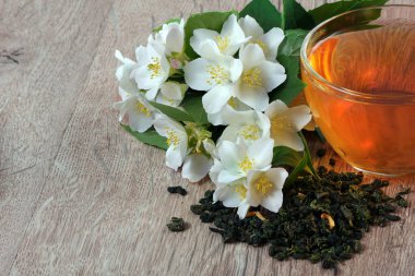 Tahta bir masada yaseminli bir fincan yeşil çay. Boşluğu kopyala