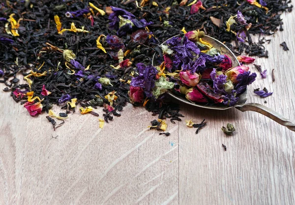 用勺子把红茶和花瓣混合在木桌上 复制空间 — 图库照片