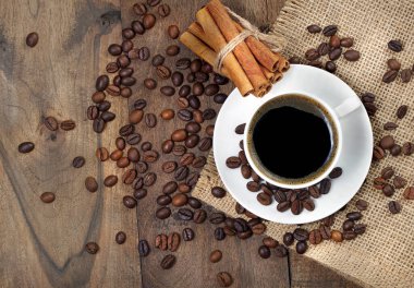 Kahve çekirdekleri ve bir fincan kahve. Beyaz bardakta kahve..