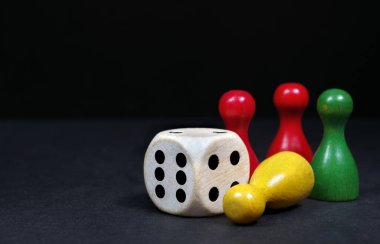 Kara tahtada zarları olan renkli oyun figürleri. seçici odak