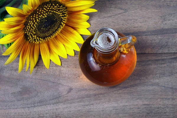 Sonnenblumenöl Und Eine Sonnenblume Auf Einem Holztisch Natürliches Pflanzenöl Ansicht — Stockfoto