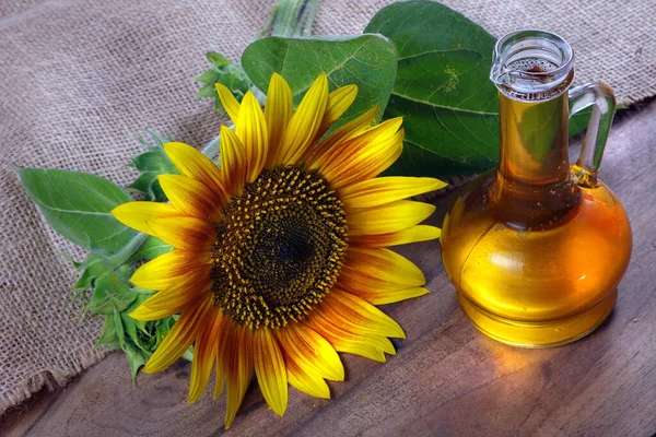 sunflower oil and a sunflower flower on the table. natural vegetable oil.