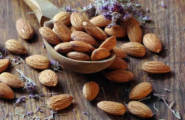 Tahta bir masada, tahta bir kaşıkta badem. Badem ve kekik.
