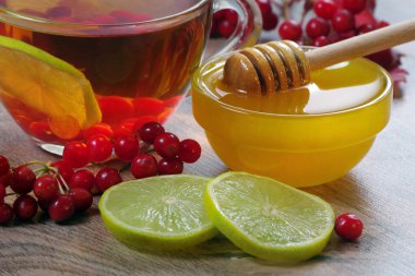 Viburnum çayı, bal ve kireç ahşap bir masada. Soğuk algınlığı ve grip için ilaç. alternatif tıp