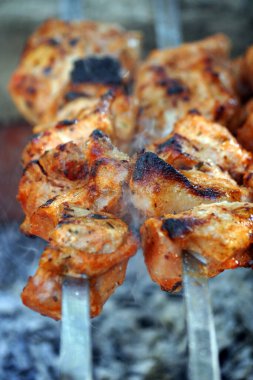 Şişlerin üstünde domuz kebabı.