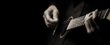 Akustik Gitar çalıyorum. Gitarist elleri ve gitarist elleri yakın çekim. Siyah ve beyaz. Boşluğu kopyala