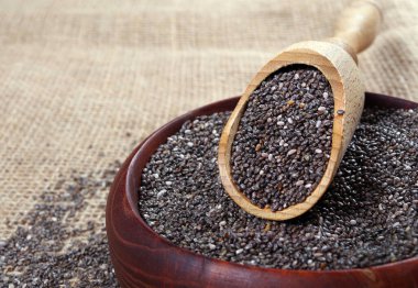 Ahşap bir kepçenin içindeki chia tohumları. sağlıklı yiyecekler