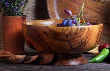 Mutfak masasında el yapımı ahşap kaplar. Tahta tabaklar, kaseler, tabaklar ve kaşıklar masanın üzerinde.