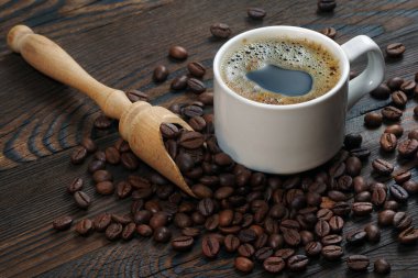 Kahve çekirdekleri ve bir fincan kahve. Beyaz bardakta kahve..