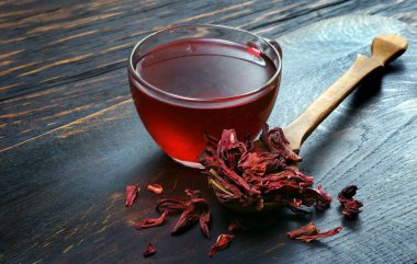 Amfibik çayı. Masadaki tahta kaşıkta kuru amber yaprağı. Grip ve soğuk algınlığı için vitamin içeceği