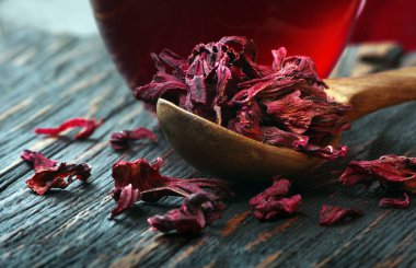 Amfibik çayı. Masadaki tahta kaşıkta kuru amber yaprağı. Grip ve soğuk algınlığı için vitamin içeceği