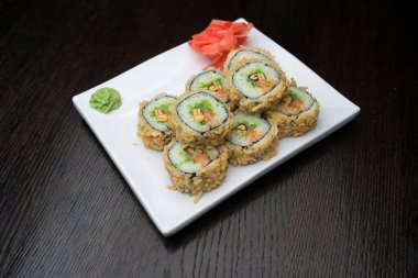 Beyaz bir tabakta suşi rulosu.