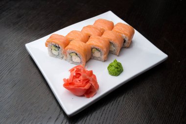 Beyaz bir tabakta suşi rulosu.