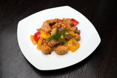 Beyaz tabakta sebzeli tavuk.