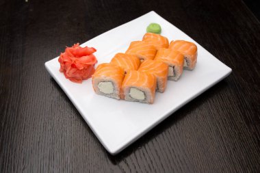 Beyaz bir tabakta suşi rulosu.