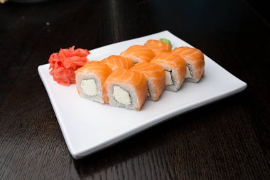 Beyaz bir tabakta suşi rulosu.