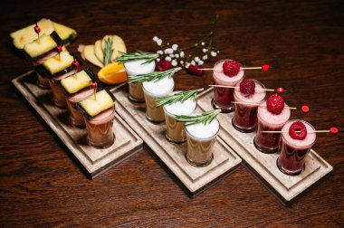 Restorandaki masada çilek, ahududu, ananas ve biberiye ile kokteyl setleri.