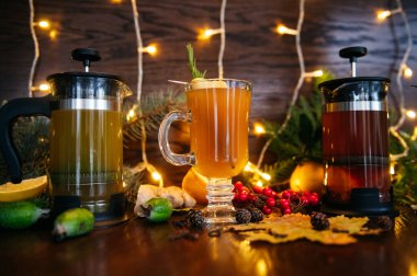 Fransız basınında sonbahar çayı ve şeffaf fincanda narenciye çayı. Restorandaki masada elma, fötr şapka ve liçi.