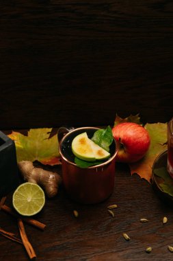 Sonbahar elma kokteyli, buzlu ve limonlu, demir bardakta restoranda masanın üstünde.